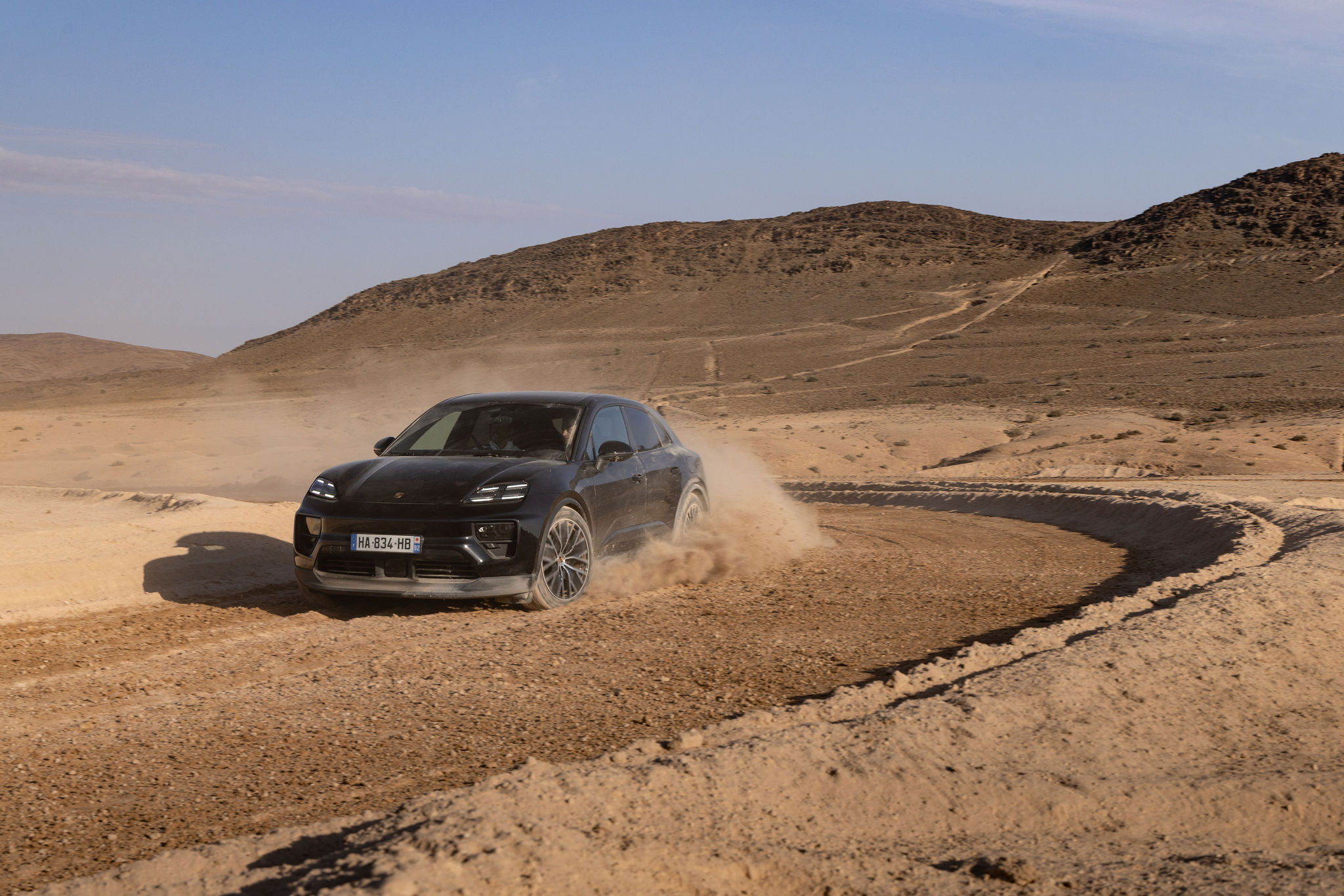 Porsche Macan électrique prenant un virage dans le désert d’Agafay