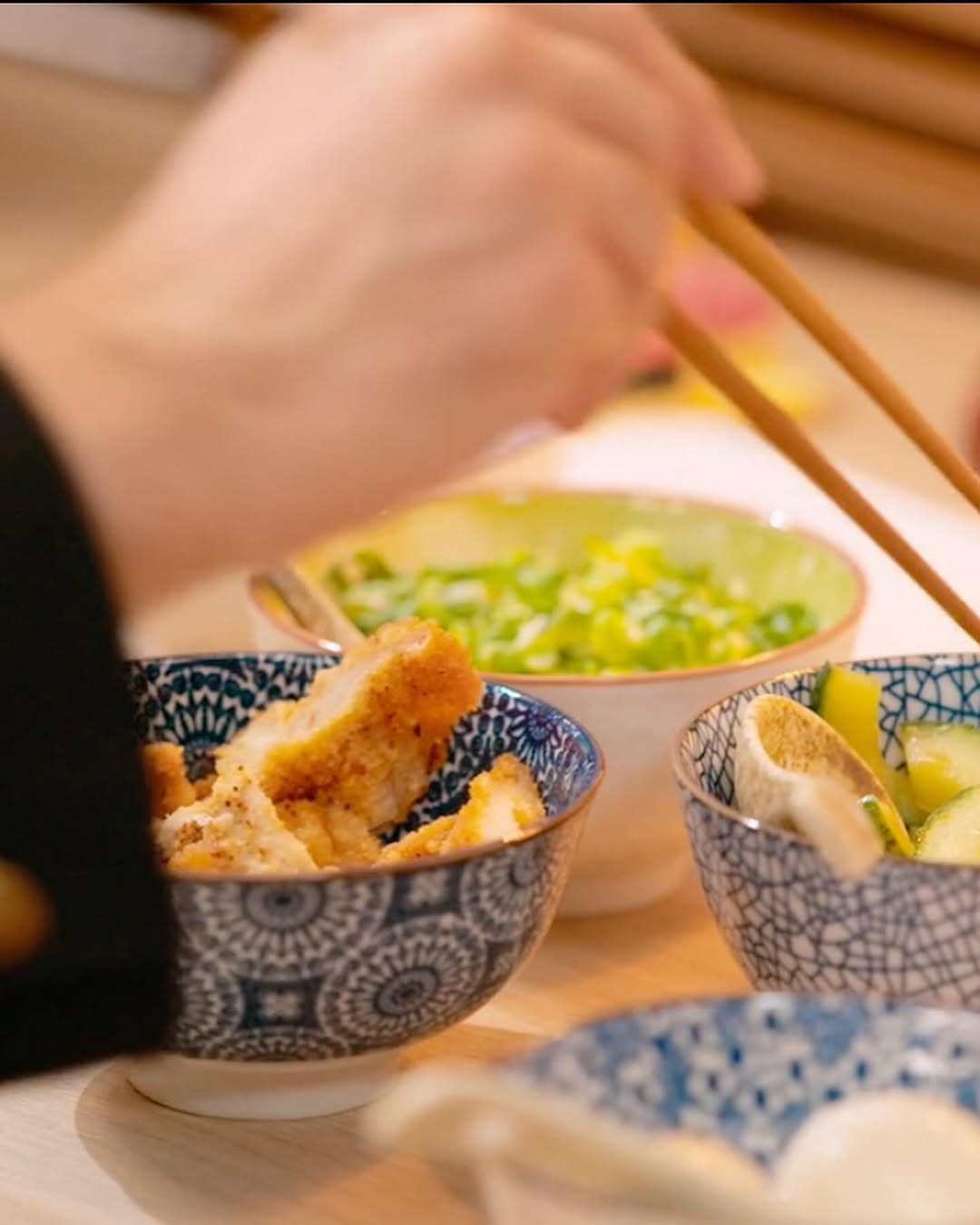 Plat japonais avec une main utilisant des baguettes